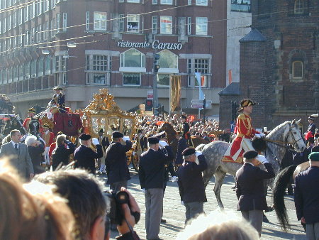 De gouden koets rondt de bocht van de Spuistraat naar het Rokin.

The golden coach. Really? It sure looks that way from this distance.
